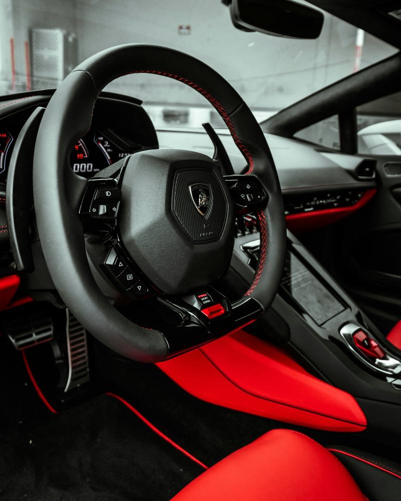 Detailed black and red sports car interior with a clean steering wheel