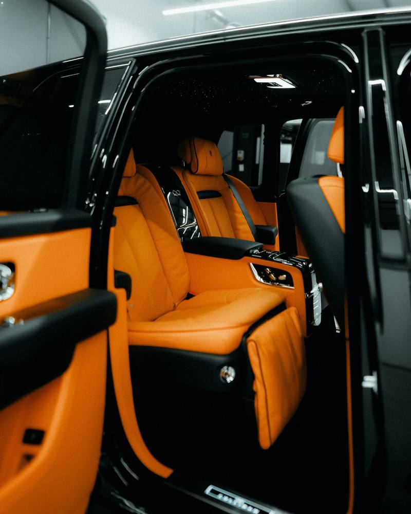 Clean orange leather rear seats seen through an open car door